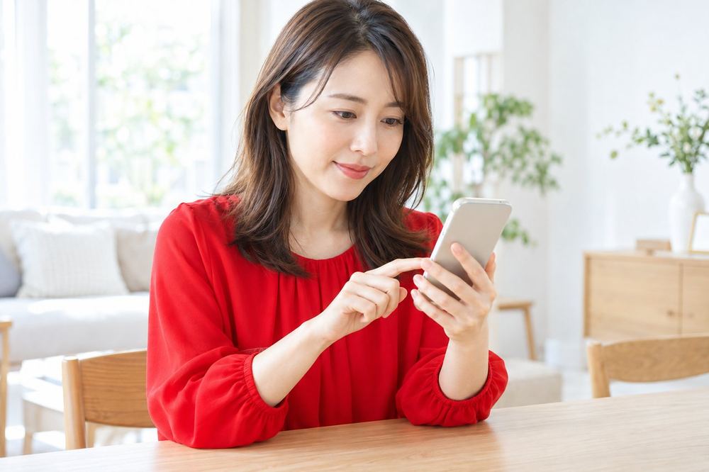 30代の女性がスマホでコメント欄の設定を開き、落ち着いて項目を一つずつ確認している