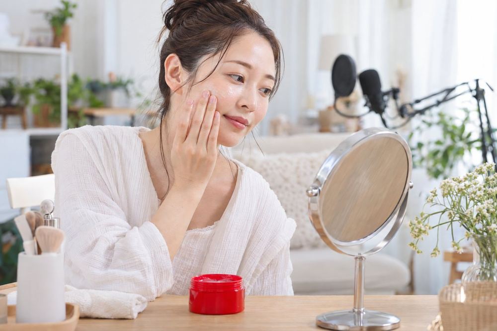 30代の女性が配信を終えたあとの部屋で、クレンジングをなじませながら鏡で肌の状態を確かめている
