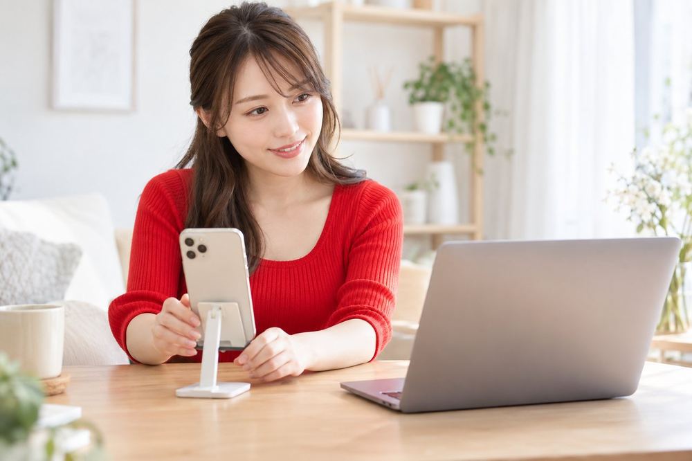 女性がスマホで配信の準備をしながら、画面越しにマネージャーと相談している