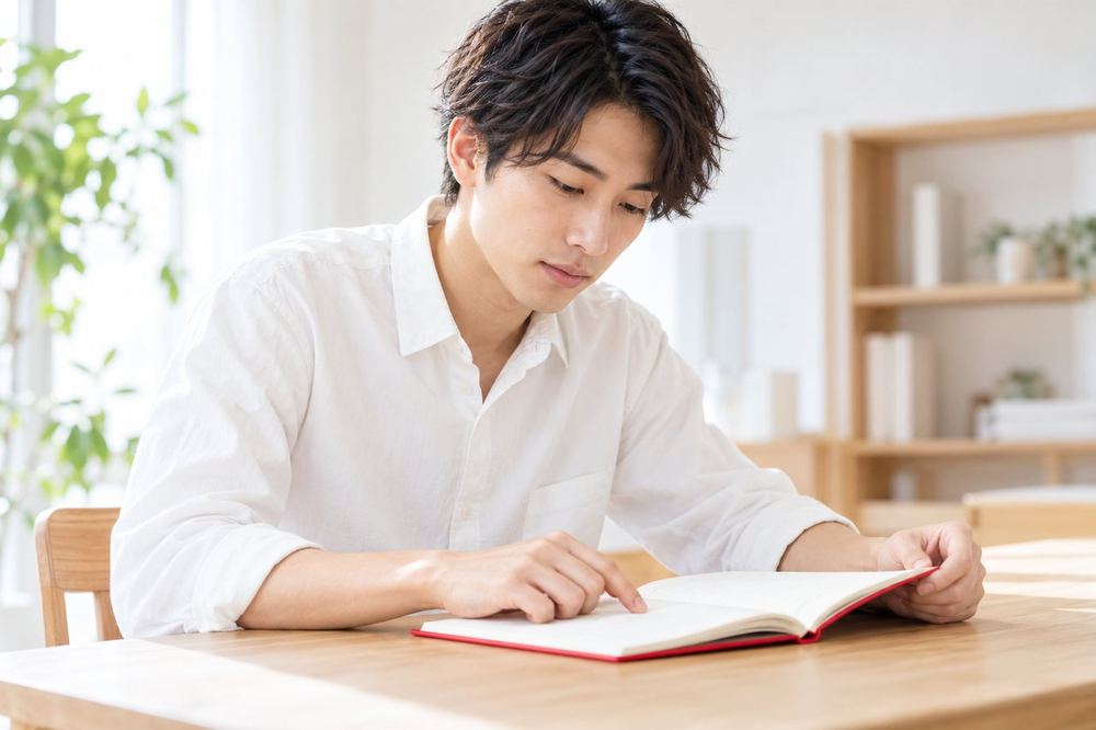 20代の男性が机でメモを見ながら、面談で聞くことを順番に確認している
