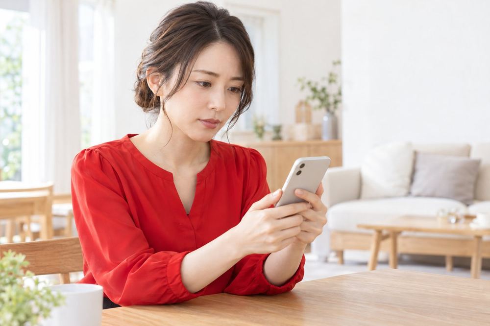 女性がスマホの通知を開き、制限の内容と期間が書かれた画面を落ち着いて読んでいる