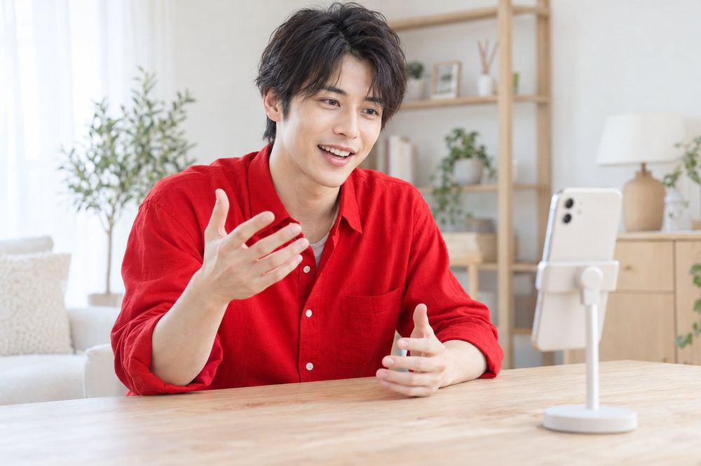 カメラに向かって、コメントをくれた視聴者の名前を呼びながら話す若い男性