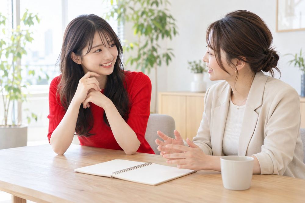 明るい打ち合わせスペースで、配信の企画についてマネージャーと話している20代の女性